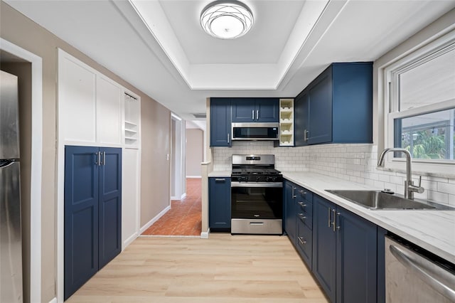 320 Tallahassee Dr NE, Saint Petersburg, FL 33702 - kitchen with stainless steel appliances, blue cabinetry, a sink, backsplash, and a raised ceiling