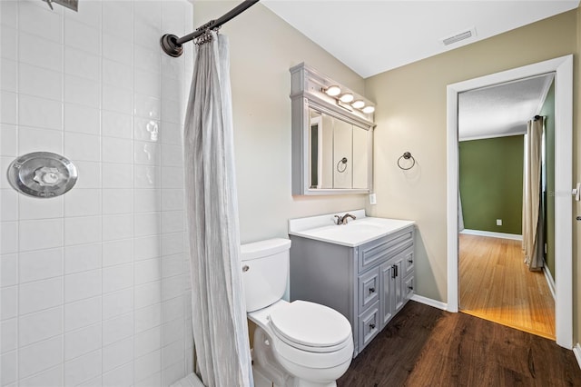 320 Tallahassee Dr NE, Saint Petersburg, FL 33702 - bathroom with wood finished floors, toilet, a tile shower, and vanity