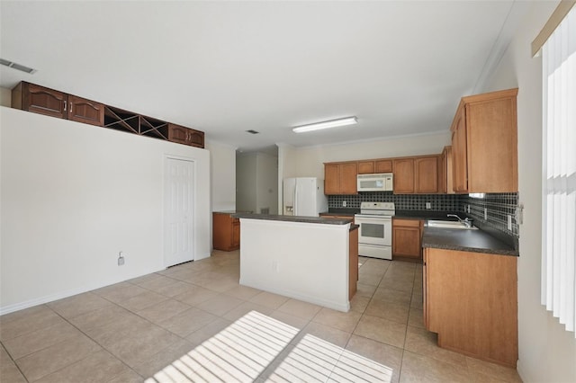 442 Graystone Blvd, Davenport, FL 33837 - kitchen with white appliances, a sink, a center island, dark countertops, and light tile patterned floors
