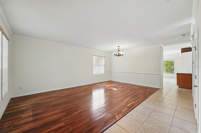 442 Graystone Blvd, Davenport, FL 33837 - empty room featuring a chandelier, light wood-style flooring, baseboards, and crown molding