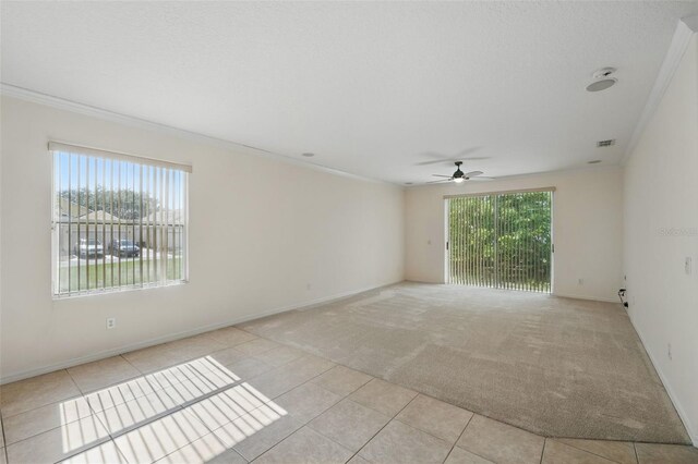 442 Graystone Blvd, Davenport, FL 33837 - unfurnished room featuring ceiling fan, ornamental molding, baseboards, light tile patterned floors, and light carpet