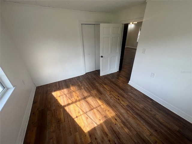 18127 US Highway 41, Spring Hill, FL 34610 - unfurnished bedroom with dark wood-style flooring, a closet, and baseboards