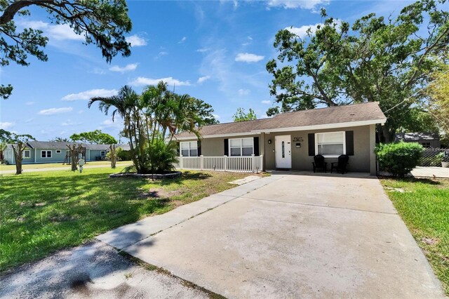 206 4th Ave NW, Ruskin, FL 33570 - ranch-style home with a porch, stucco siding, a front yard, and concrete driveway