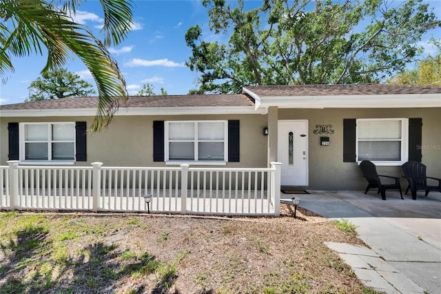 206 4th Ave NW, Ruskin, FL 33570 - ranch-style home featuring stucco siding, a porch, and roof with shingles