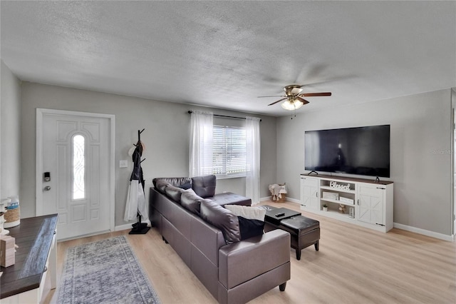 206 4th Ave NW, Ruskin, FL 33570 - living room featuring light wood-type flooring, a textured ceiling, a ceiling fan, and baseboards