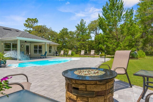 10197 Meadow Wren Ave, Weeki Wachee, FL 34613 - outdoor pool featuring a fire pit, a patio area, ceiling fan, and a lawn