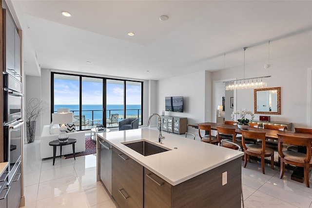 100 1st Ave N Unit 2703, Saint Petersburg, FL 33701 - kitchen featuring a sink, modern cabinets, open floor plan, light marble finish flooring, and an island with sink