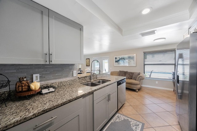 1706 Sloop Pl, Brandon, FL 33511 - kitchen with appliances with stainless steel finishes, a sink, backsplash, a tray ceiling, and healthy amount of natural light