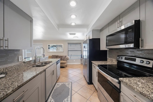 1706 Sloop Pl, Brandon, FL 33511 - kitchen featuring stainless steel appliances, a sink, a raised ceiling, and backsplash