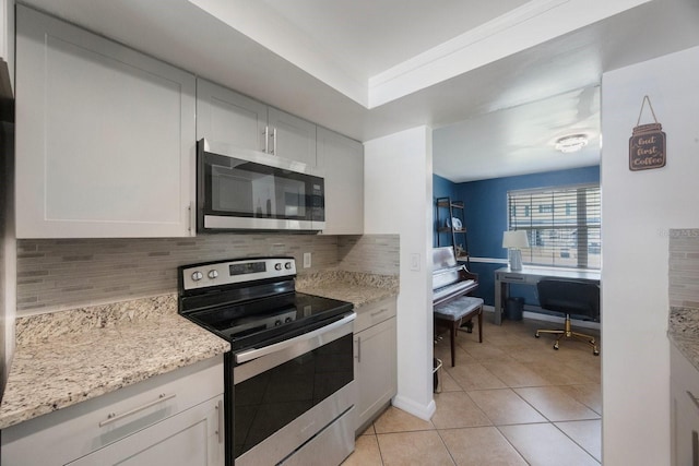 1706 Sloop Pl, Brandon, FL 33511 - kitchen with appliances with stainless steel finishes, tasteful backsplash, light tile patterned floors, white cabinets, and light stone countertops
