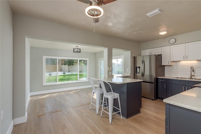 2010 Bayview Pl, Indian Rocks Beach, FL 33785 - kitchen with a sink, stainless steel fridge, a ceiling fan, and light wood-type flooring