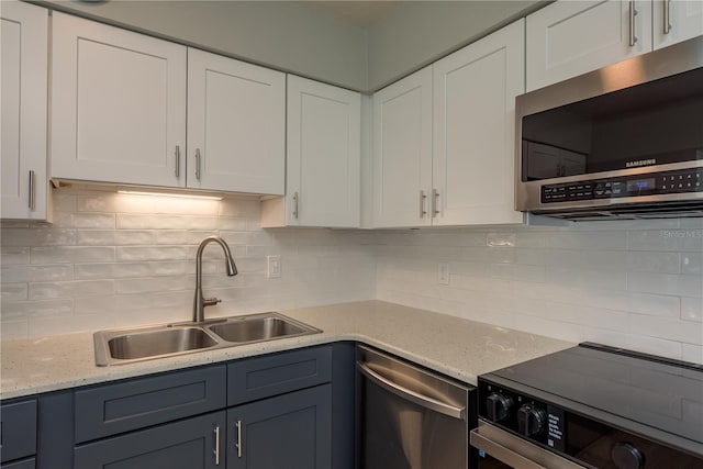 2010 Bayview Pl, Indian Rocks Beach, FL 33785 - kitchen with stainless steel appliances, a sink, white cabinets, and backsplash
