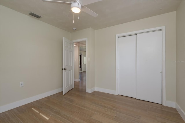 2010 Bayview Pl, Indian Rocks Beach, FL 33785 - unfurnished bedroom featuring light wood-style floors, baseboards, a closet, and ceiling fan