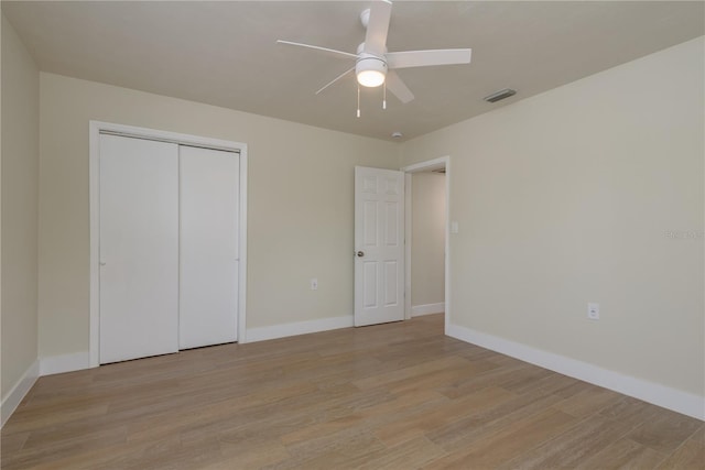 2010 Bayview Pl, Indian Rocks Beach, FL 33785 - unfurnished bedroom featuring light wood finished floors, baseboards, a closet, and a ceiling fan