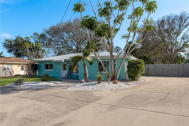 2010 Bayview Pl, Indian Rocks Beach, FL 33785 - view of front of house with a standing seam roof, metal roof, stucco siding, concrete driveway, and a porch