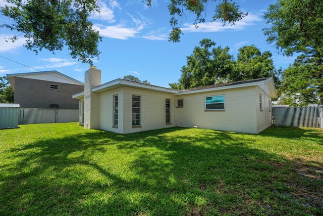 6282 41st Ave N, Saint Petersburg, FL 33709 - rear view of property with a chimney and concrete block siding
