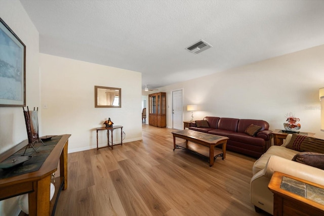 6282 41st Ave N, Saint Petersburg, FL 33709 - living area with light wood-type flooring, baseboards, and a textured ceiling