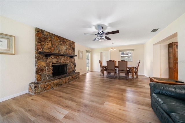 6282 41st Ave N, Saint Petersburg, FL 33709 - living room featuring ceiling fan, a stone fireplace, baseboards, and light wood finished floors