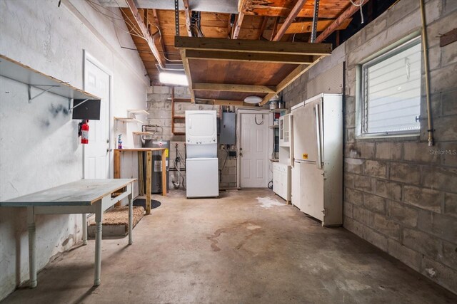 6282 41st Ave N, Saint Petersburg, FL 33709 - basement featuring electric water heater, stacked washing machine and dryer, and a workshop area