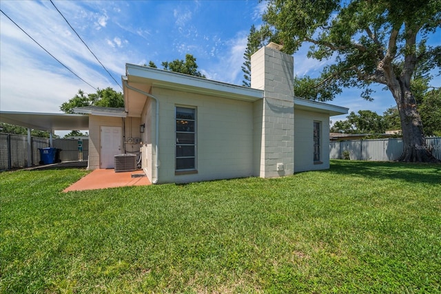 6282 41st Ave N, Saint Petersburg, FL 33709 - back of property featuring a chimney, concrete block siding, central AC unit, and a patio