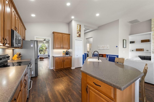 2350 126th Dr E, Parrish, FL 34219 - kitchen with stainless steel appliances, lofted ceiling, dark wood-type flooring, dark countertops, and a kitchen breakfast bar