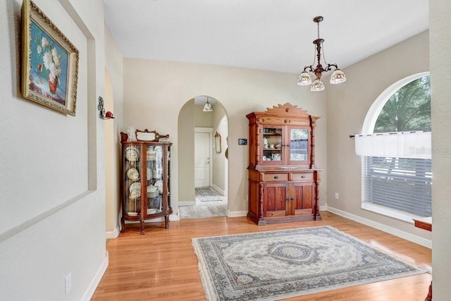 613 Sportsman Park Dr, Seffner, FL 33584 - foyer entrance featuring arched walkways, light wood-type flooring, a chandelier, and baseboards