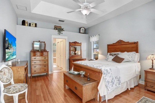 613 Sportsman Park Dr, Seffner, FL 33584 - bedroom featuring a raised ceiling, light wood-style floors, baseboards, ceiling fan, and ensuite bathroom
