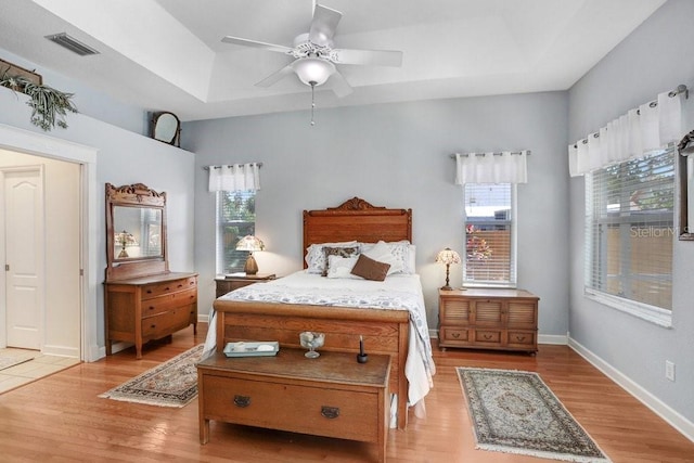 613 Sportsman Park Dr, Seffner, FL 33584 - bedroom with a tray ceiling, light wood-style floors, and multiple windows