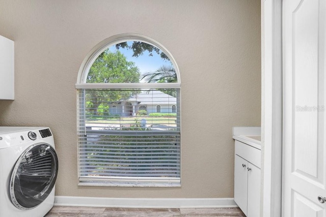 613 Sportsman Park Dr, Seffner, FL 33584 - washroom featuring washer / clothes dryer, cabinet space, baseboards, and light wood finished floors