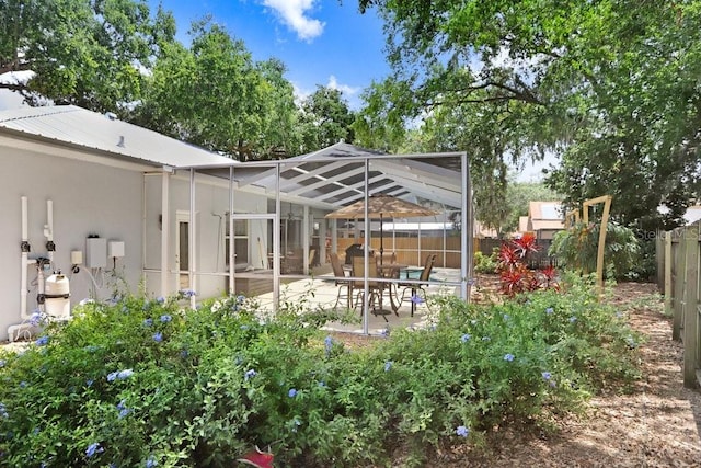 613 Sportsman Park Dr, Seffner, FL 33584 - back of house featuring stucco siding, a fenced backyard, a patio, glass enclosure, and metal roof