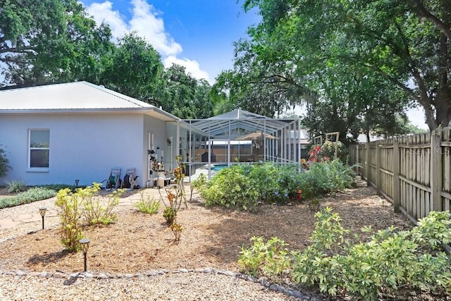613 Sportsman Park Dr, Seffner, FL 33584 - rear view of property featuring a fenced backyard, glass enclosure, and stucco siding