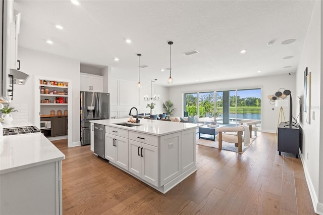 6123 Golden Nettle Dr, Apollo Beach, FL 33572 - kitchen featuring a sink, appliances with stainless steel finishes, light wood-type flooring, white cabinets, and light countertops