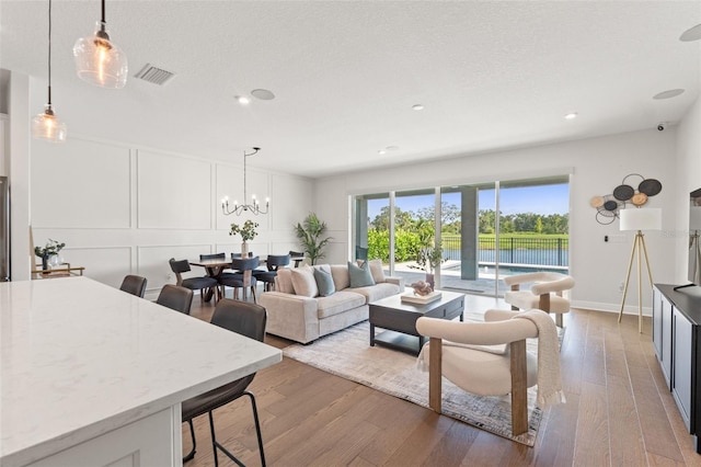 6123 Golden Nettle Dr, Apollo Beach, FL 33572 - living area featuring wood finished floors, recessed lighting, a decorative wall, a chandelier, and baseboards