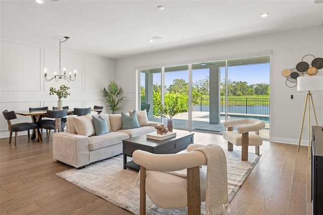 6123 Golden Nettle Dr, Apollo Beach, FL 33572 - living area with a decorative wall, light wood finished floors, a chandelier, recessed lighting, and baseboards