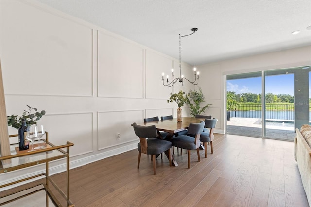 6123 Golden Nettle Dr, Apollo Beach, FL 33572 - dining area with a decorative wall, wood finished floors, a chandelier, and a water view