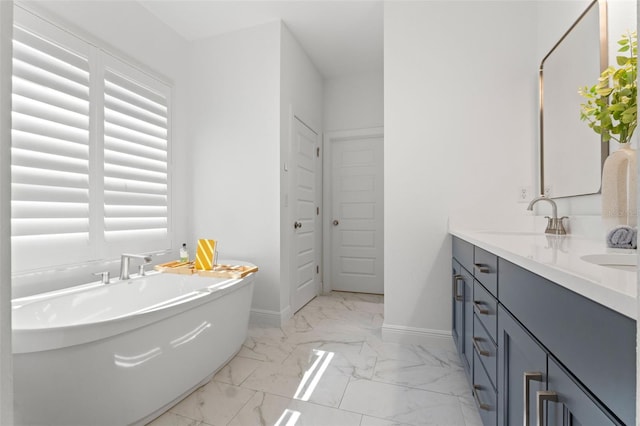 6123 Golden Nettle Dr, Apollo Beach, FL 33572 - full bathroom featuring marble look tile flooring, double vanity, a freestanding bath, and baseboards