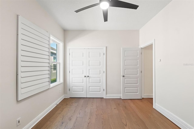 6123 Golden Nettle Dr, Apollo Beach, FL 33572 - unfurnished bedroom featuring wood finished floors, a closet, baseboards, and a ceiling fan