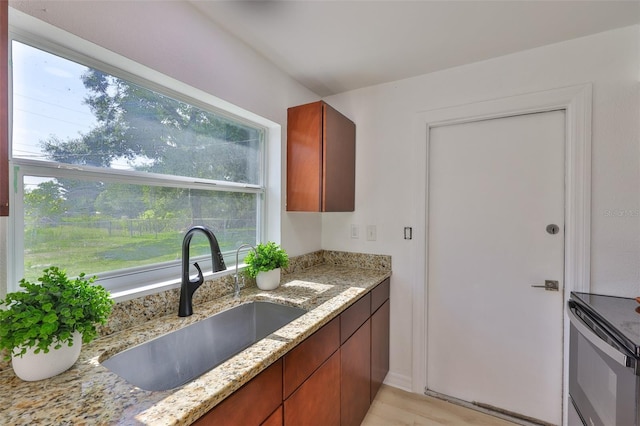 1110 Waterview Blvd E, Lakeland, FL 33801 - kitchen with a sink, range, light stone countertops, and light wood-type flooring