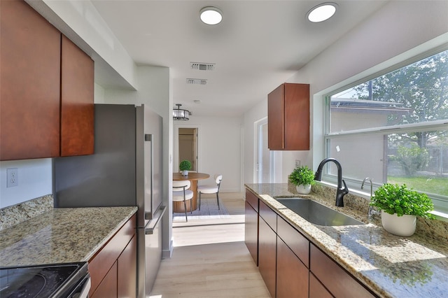 1110 Waterview Blvd E, Lakeland, FL 33801 - kitchen with a sink, light wood-type flooring, and light stone countertops
