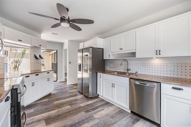 660 Channing Dr, Palm Harbor, FL 34684 - kitchen with appliances with stainless steel finishes, a sink, backsplash, dark wood-style floors, and white cabinets
