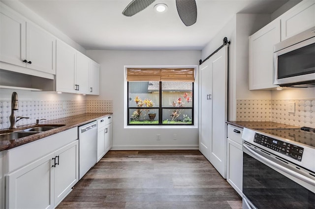 660 Channing Dr, Palm Harbor, FL 34684 - kitchen with stainless steel appliances, a sink, tasteful backsplash, and a barn door