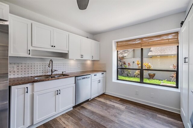 660 Channing Dr, Palm Harbor, FL 34684 - kitchen with appliances with stainless steel finishes, a sink, decorative backsplash, dark stone counters, and white cabinets