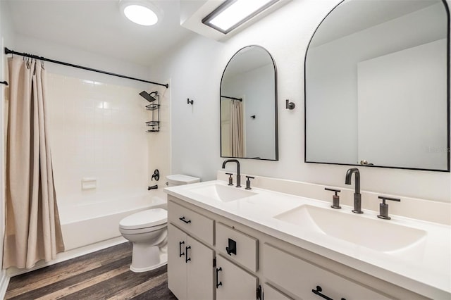 660 Channing Dr, Palm Harbor, FL 34684 - bathroom with toilet, double vanity, shower / bath combo with shower curtain, and wood finished floors