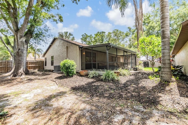 660 Channing Dr, Palm Harbor, FL 34684 - rear view of house featuring a sunroom, central AC, and stucco siding