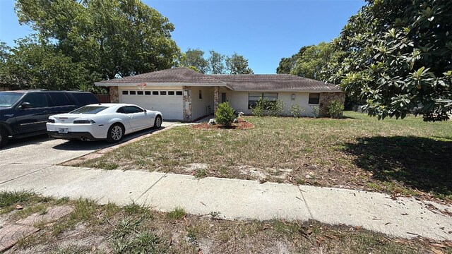 7700 Willow Brook Ct, Hudson, FL 34667 - ranch-style house featuring an attached garage, a front yard, driveway, stone siding, and stucco siding