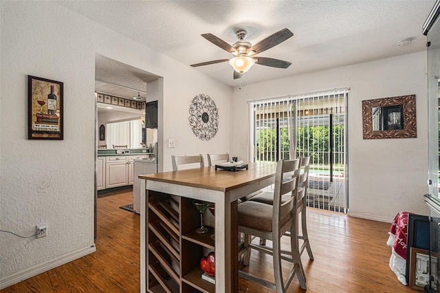 7700 Willow Brook Ct, Hudson, FL 34667 - dining area with a textured ceiling, wood finished floors, a ceiling fan, and a textured wall