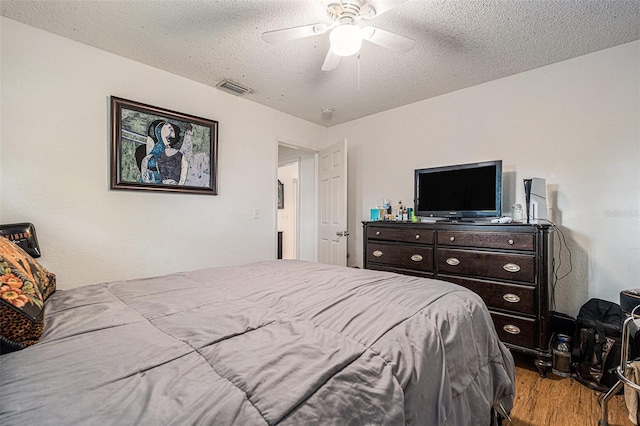 7700 Willow Brook Ct, Hudson, FL 34667 - bedroom with wood finished floors, a textured ceiling, and a ceiling fan