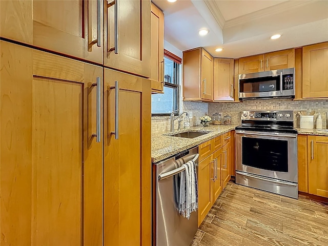 105 4th Ave NE Unit 426, Saint Petersburg, FL 33701 - kitchen featuring stainless steel appliances, ornamental molding, light stone counters, light wood-style flooring, and backsplash