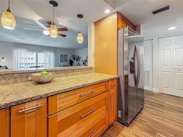 105 4th Ave NE Unit 426, Saint Petersburg, FL 33701 - kitchen with stainless steel fridge, brown cabinets, light wood-style flooring, ceiling fan, and recessed lighting