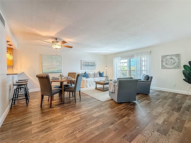105 4th Ave NE Unit 426, Saint Petersburg, FL 33701 - dining room with dark wood-style flooring, a textured ceiling, and a ceiling fan